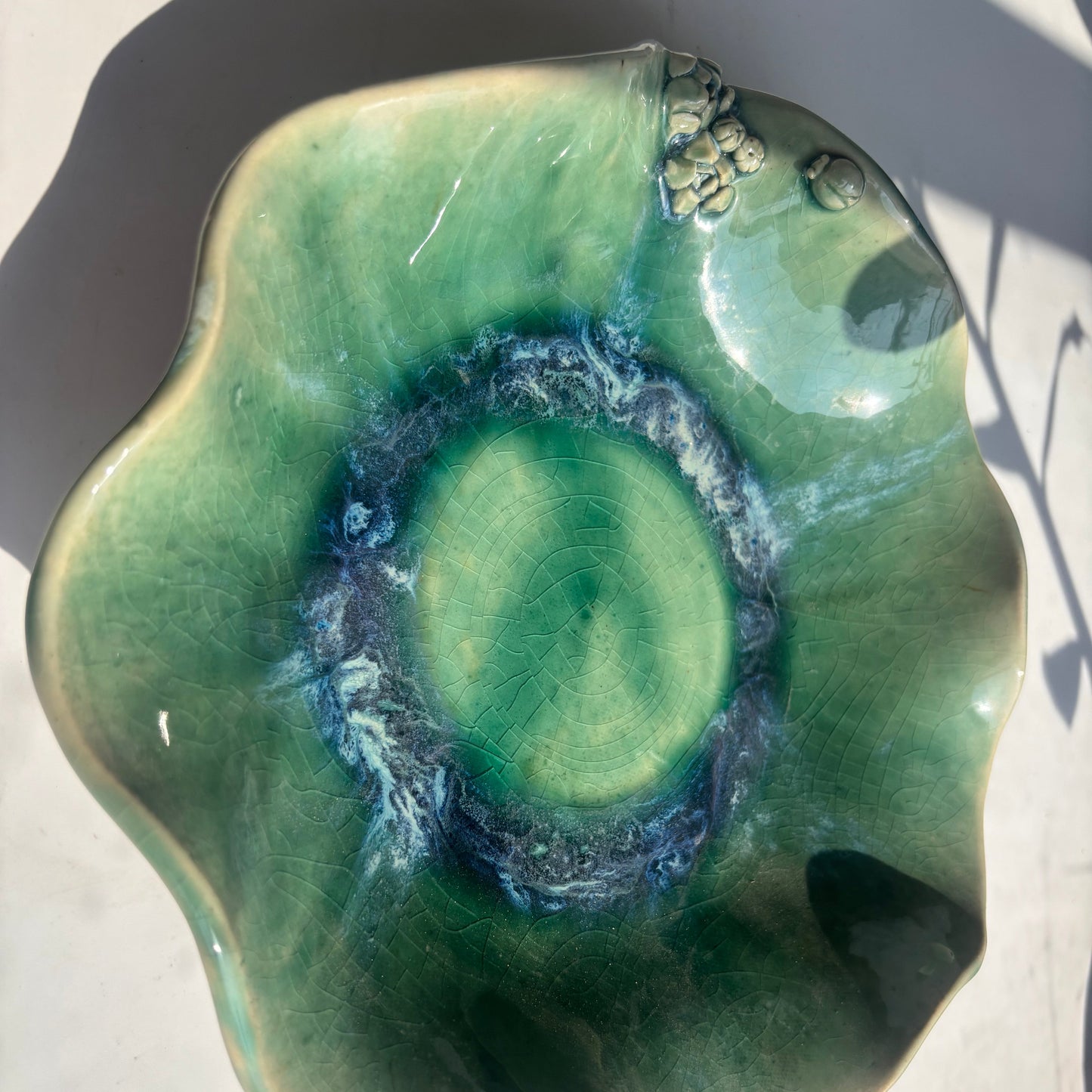Green ceramic bowl with swirling pattern on a light background