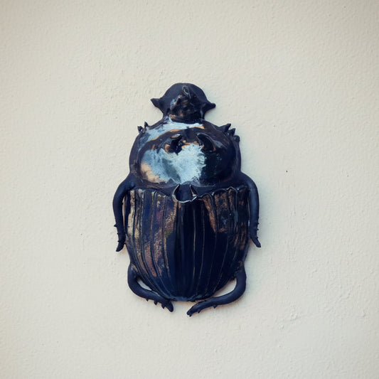 Decorative beetle sculpture on a white background