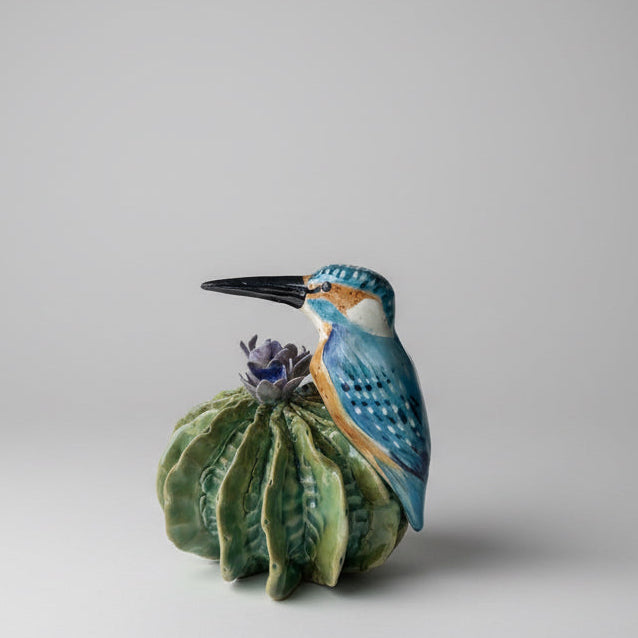 Ceramic kingfisher bird with a flower on a white background