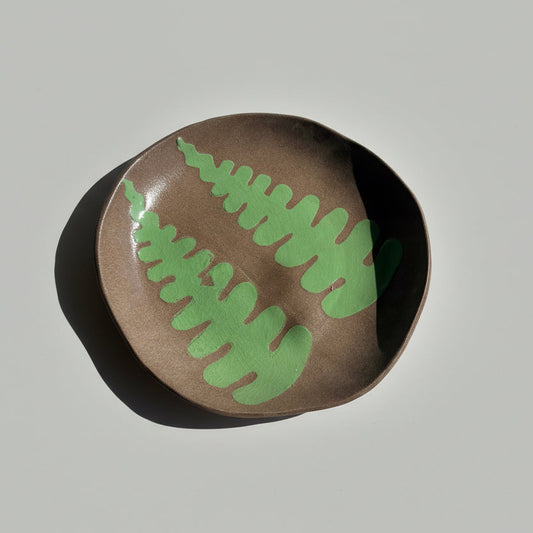 Brown stone with green leaf patterns on a white background